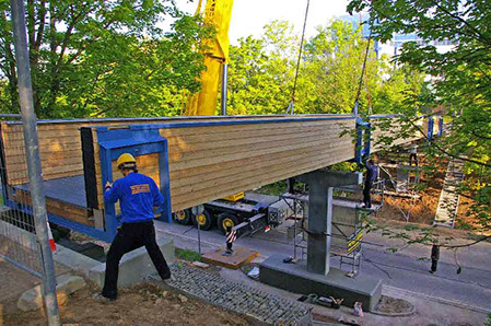 Montage des Brückenüberbaues, Brückenüberbau ist eine Holzkonstruktion, gelagert auf Stahlbetonpfeiler und Widerlager